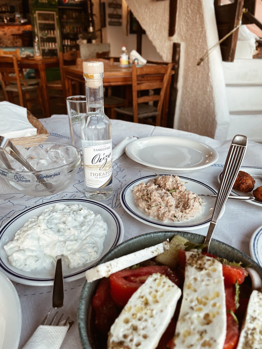 Enjoy a traditional Greek meal setup with authentic dishes and Ouzo in Pefkos, Greece.