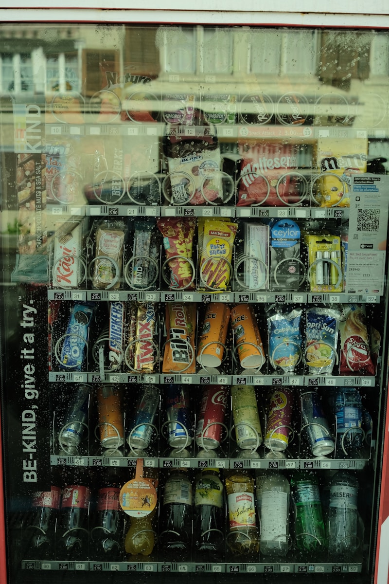 A vending machine with soda and soda cans