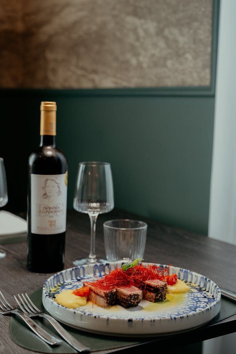 A delicious gourmet meal served with red wine at a cozy restaurant in Calabria, Italy.